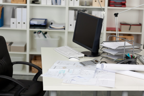 View of computer calculator and documents on office desk