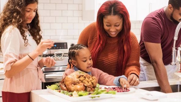 Family and friends cooking Thanksgiving dinner together.